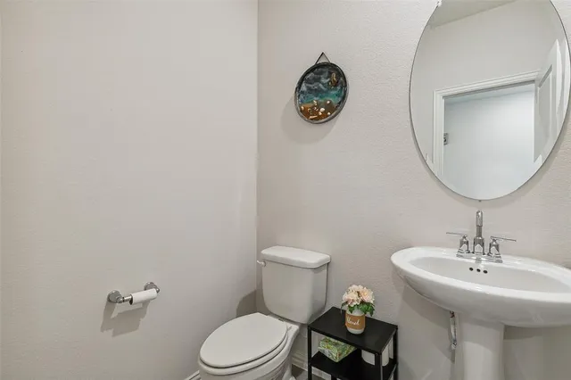 a bathroom with a toilet a sink and mirror