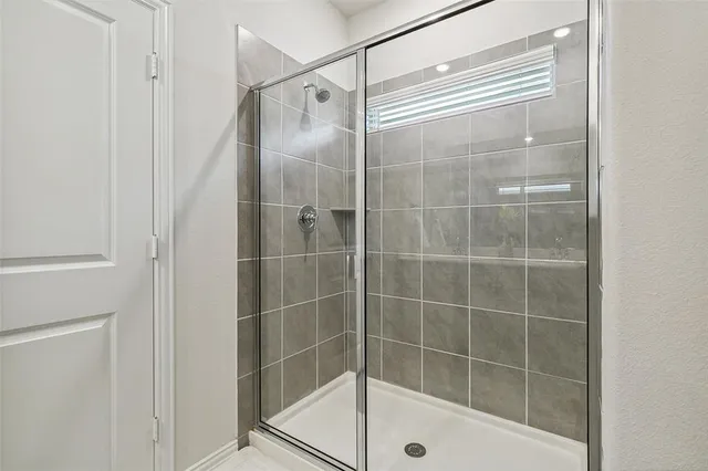 a bathroom with a glass shower door