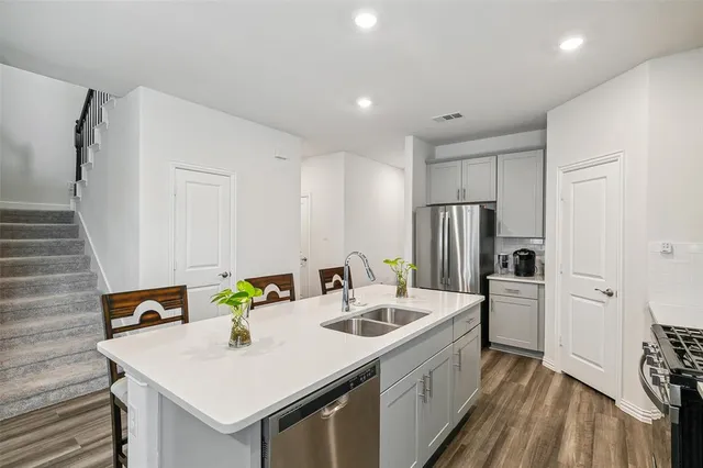 a kitchen that has a sink a stove and chairs