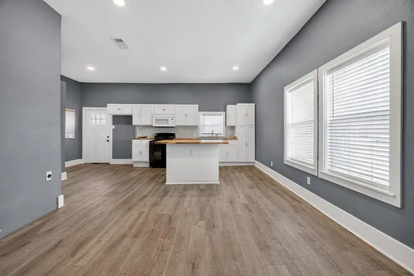a view of kitchen with wooden floor and electronic appliances