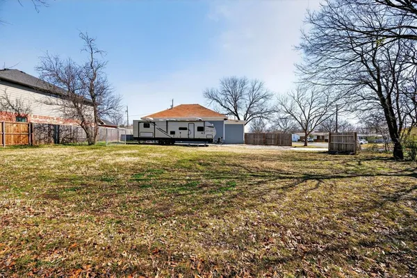 a view of a yard with a house and a large tree