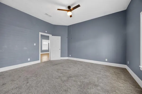 a view of an empty room with a ceiling fan