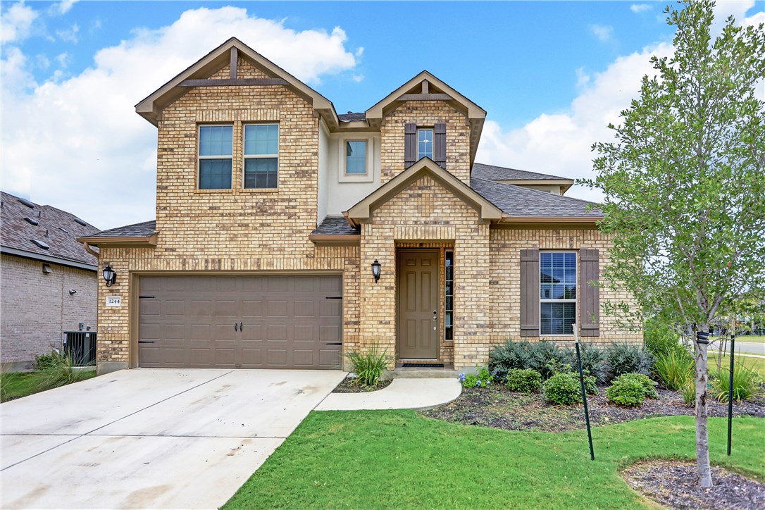 1244 Siena Sunset Road Leander, TX 78641 - Photo 1 of 1 a front view of a house with a yard and garage