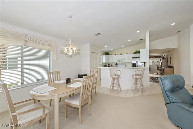 a living room with furniture kitchen view and a chandelier