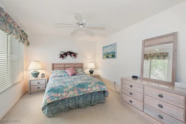 a view of a livingroom with a chandelier fan and windows
