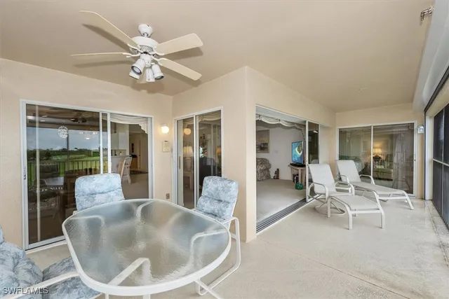 a view of a white house with a potted plant and a large tree