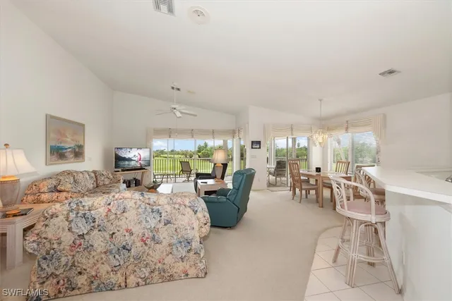 a living room with furniture kitchen view and a chandelier