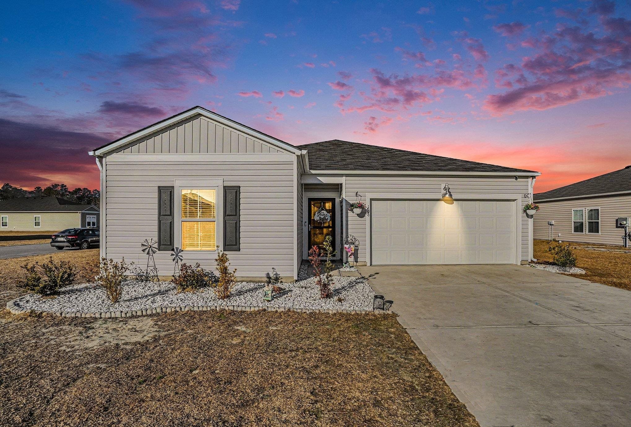 Single story home with driveway, an attached garage, and a shingled roof