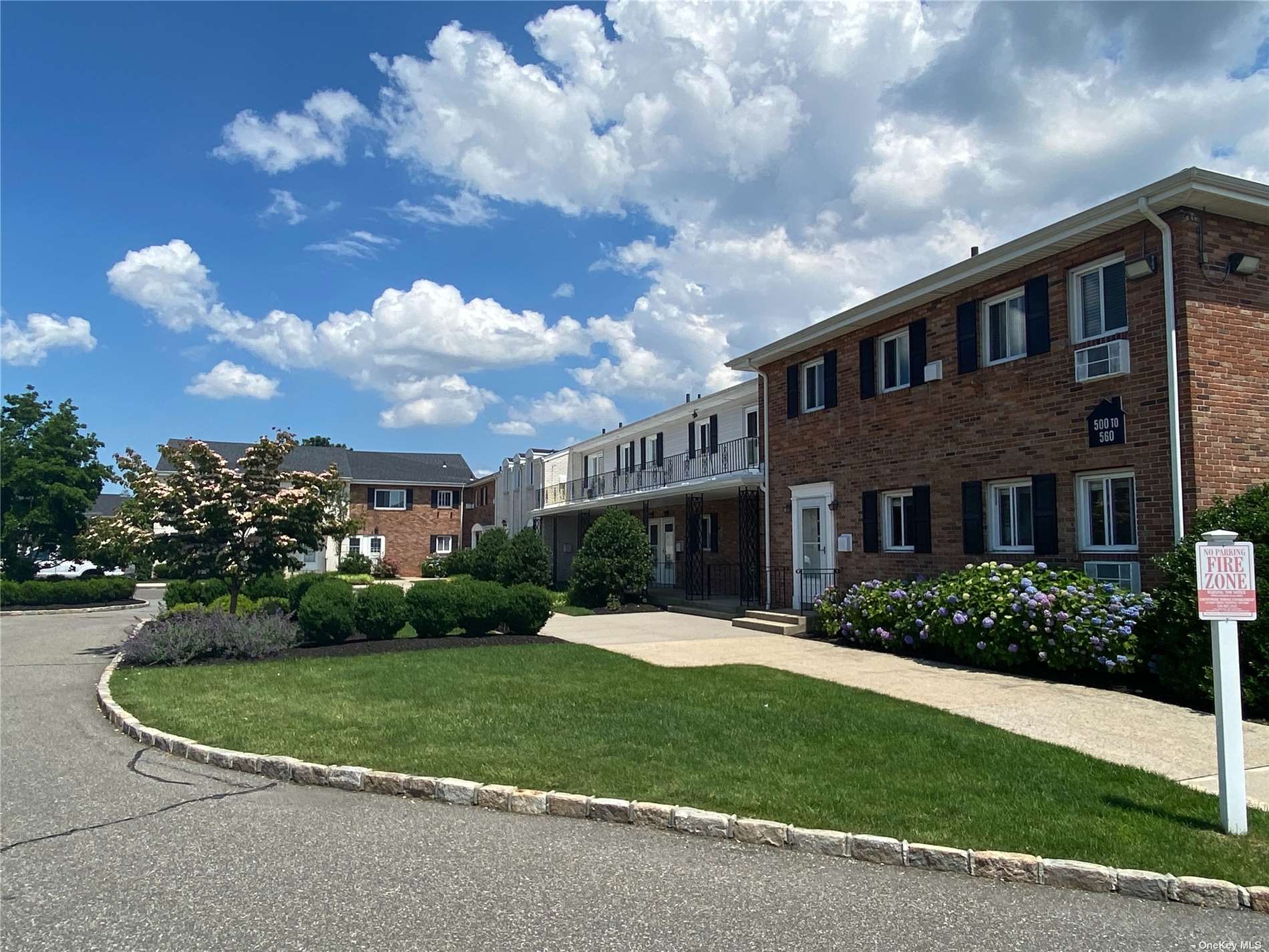 a view of a house with a big yard plants and large trees