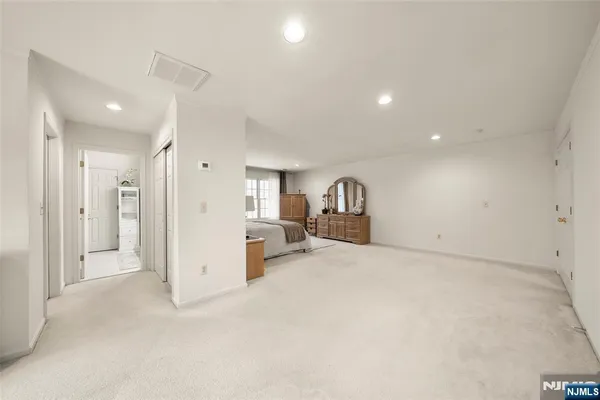 en empty room with closet and a view of bedroom