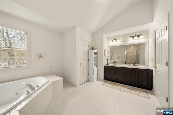 a bathroom with a tub a sink and mirror