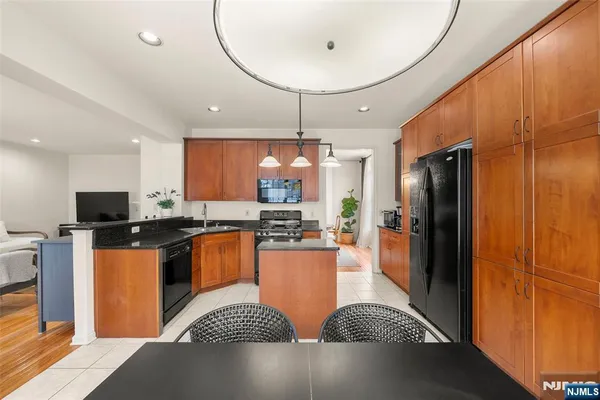 a kitchen with stainless steel appliances granite countertop a refrigerator a stove and a microwave