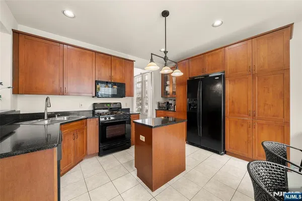 a kitchen with stainless steel appliances granite countertop a refrigerator a stove a sink and a microwave