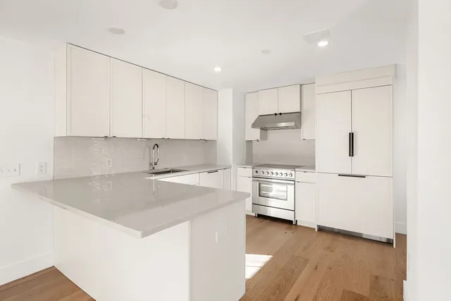 a kitchen with kitchen island a stove a sink and a refrigerator