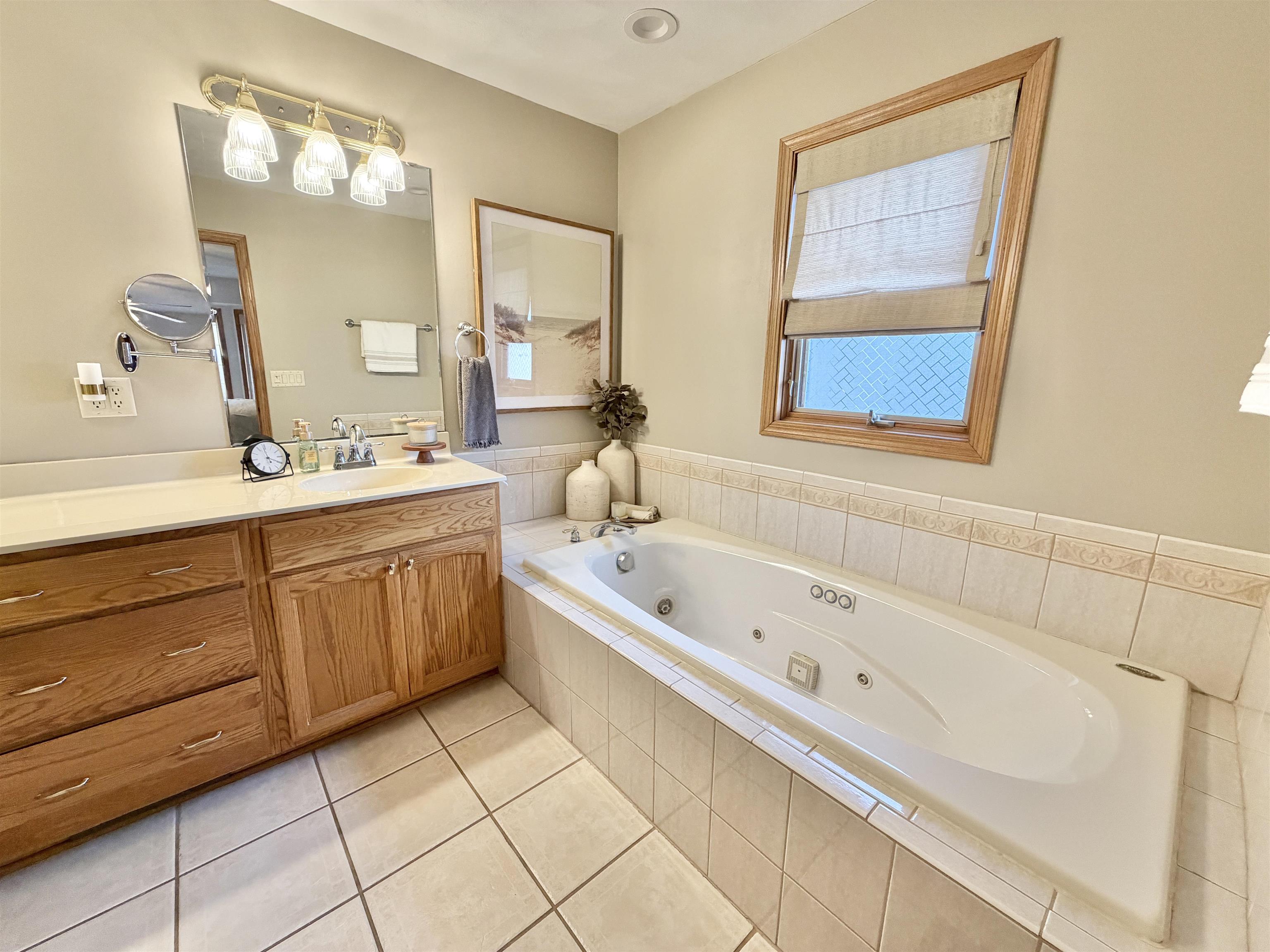 9102 River View Trail Roscoe, IL 61073 - Photo 20 of 40 a bathroom with a tub sink and mirror