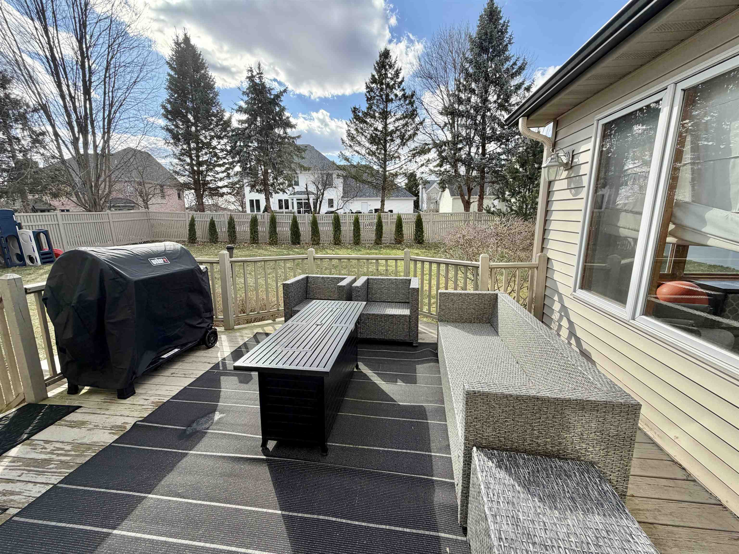 9102 River View Trail Roscoe, IL 61073 - Photo 38 of 40 a view of a patio with couches and table with wooden floor and fence