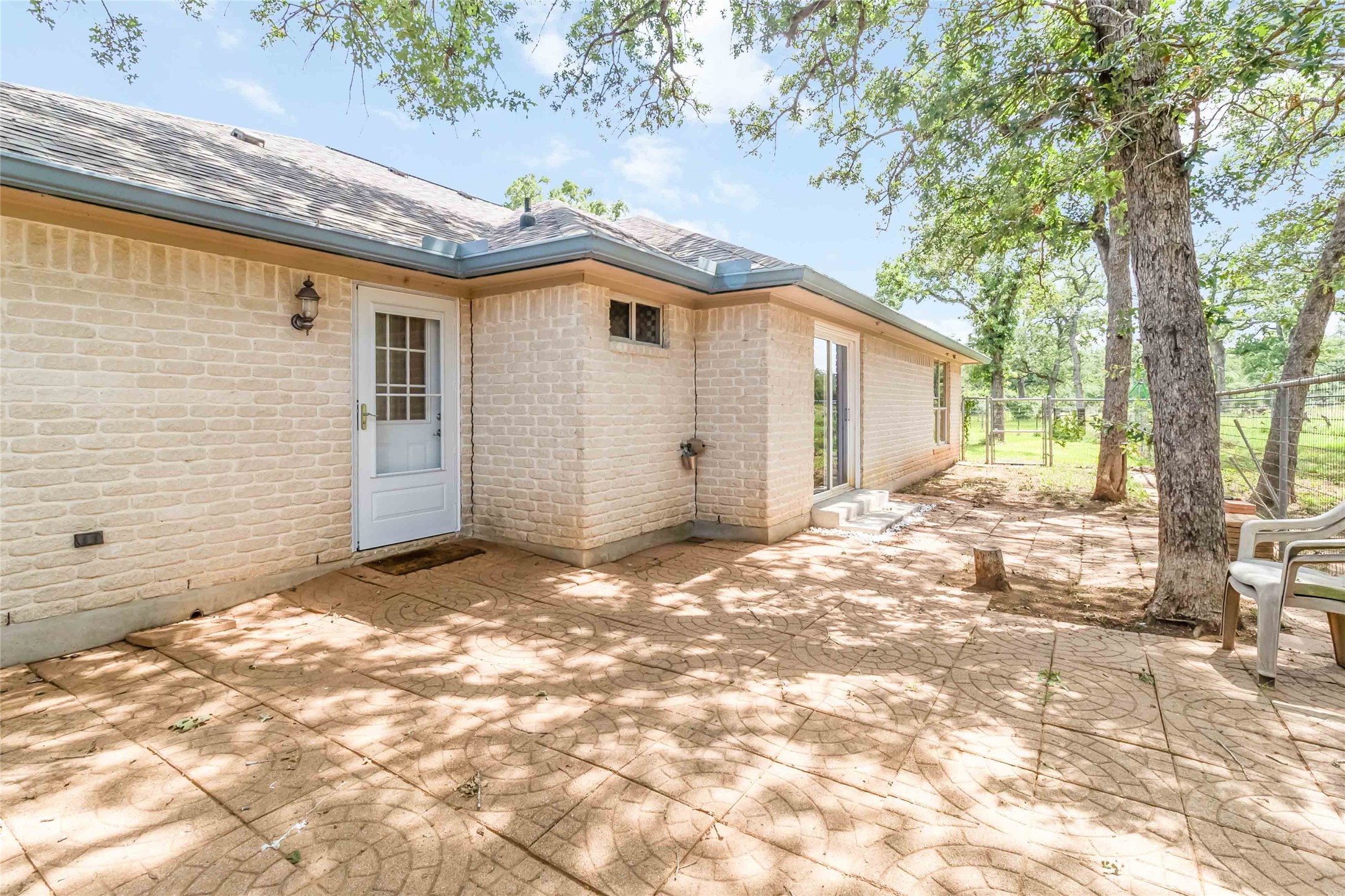 1208 Jeddo Road Rosanky, TX 78953 - Photo 33 of 40 A spacious back patio offers ample room for relaxation and entertaining amidst a verdant backdrop.