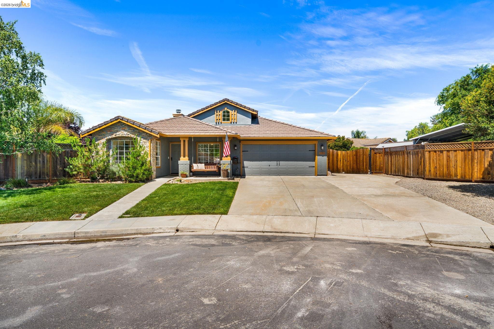 1186 El Rio Court Livermore, CA 94551 - Photo 57 of 60 Exterior featuring a two-car garage, stone veneer accents, and a covered porch entry