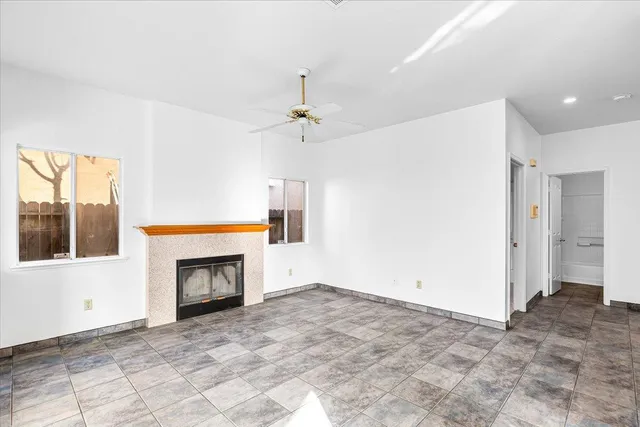 a view of an empty room with a fireplace and a window