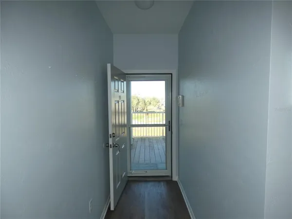 a view of a hallway with wooden floor and a window