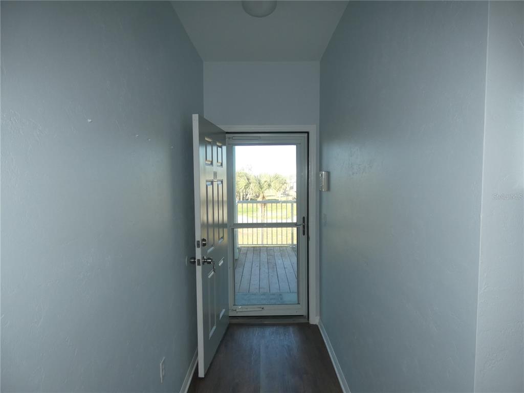 502 Main Street, Unit 106 Horseshoe Beach, FL 32648 - Photo 6 of 27 a view of a hallway with wooden floor and a window