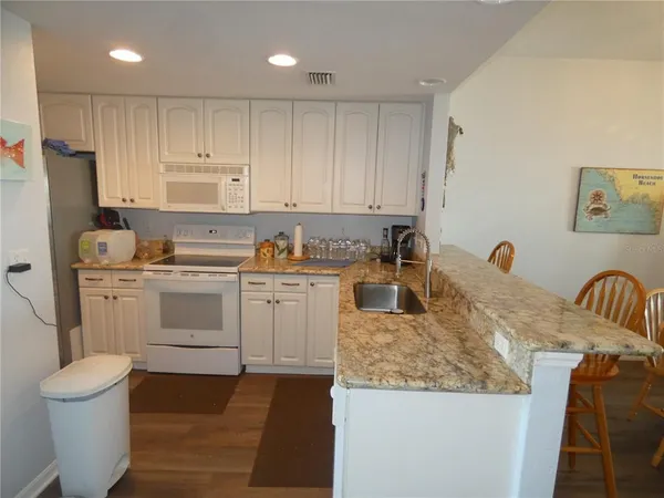 a kitchen that has a sink cabinets and a refrigerator