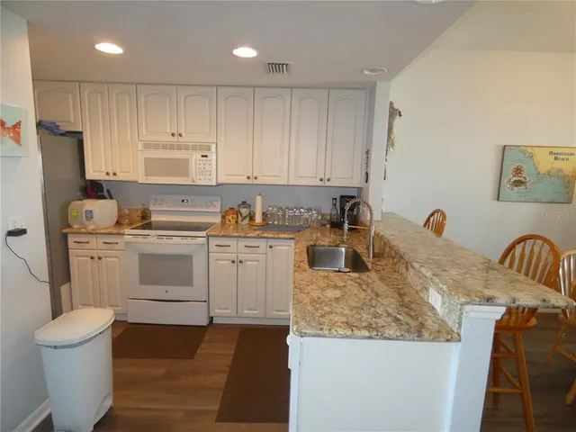 a kitchen that has a sink cabinets and a refrigerator