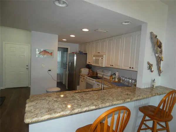 a kitchen with stainless steel appliances granite countertop a sink and a refrigerator