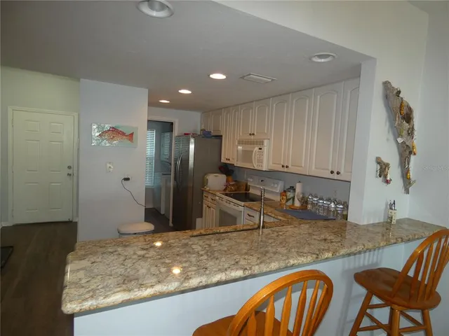 a kitchen with stainless steel appliances granite countertop a sink and a refrigerator
