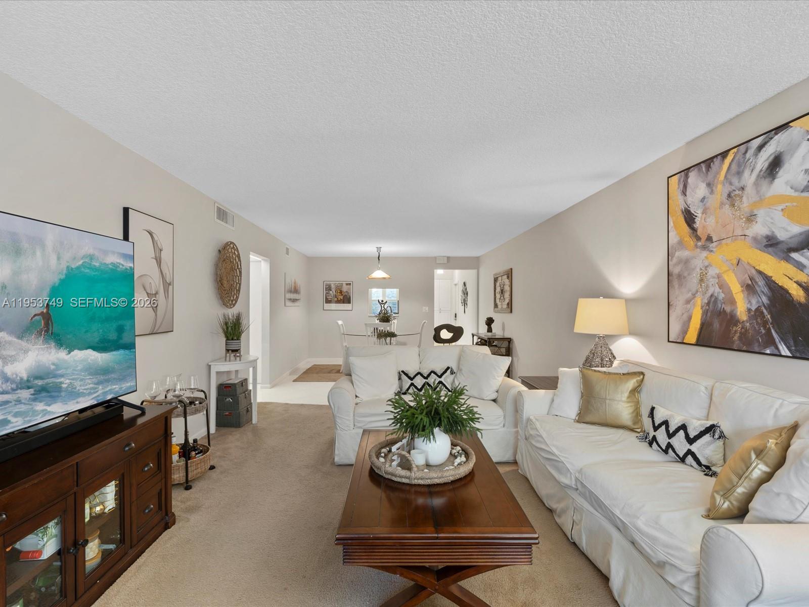 a living room with furniture and floor to ceiling windows