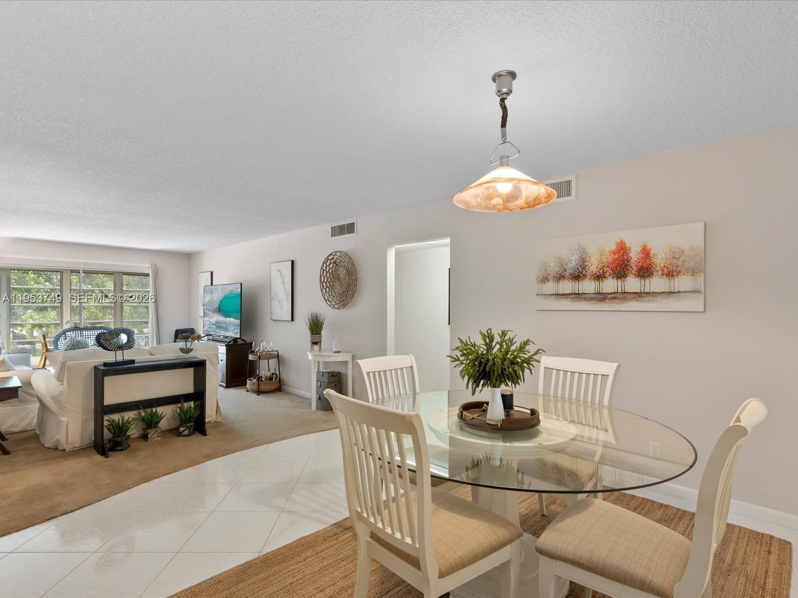 2004 Granada Drive, Unit O2 Coconut Creek, FL 33066 - Photo 4 of 26 a dining room with furniture a potted plant and a chandelier