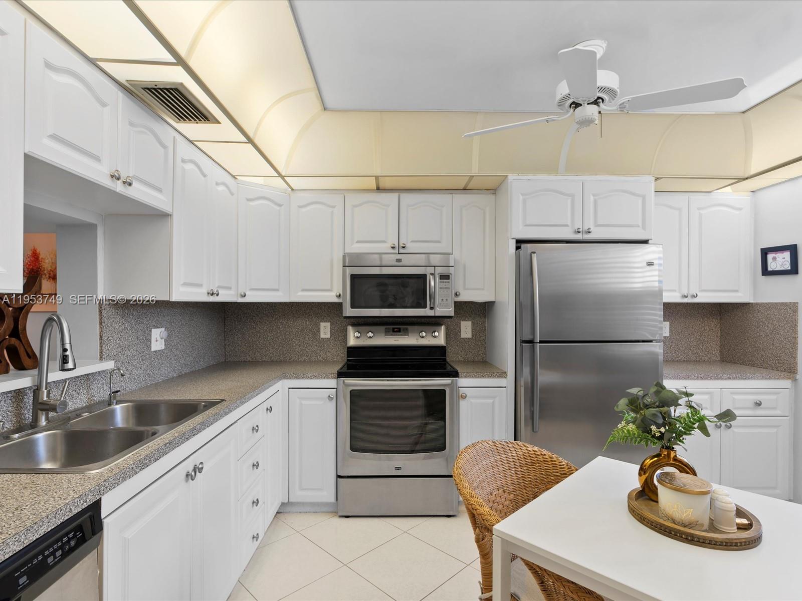 2004 Granada Drive, Unit O2 Coconut Creek, FL 33066 - Photo 7 of 26 a kitchen with stainless steel appliances granite countertop a sink refrigerator stove and microwave