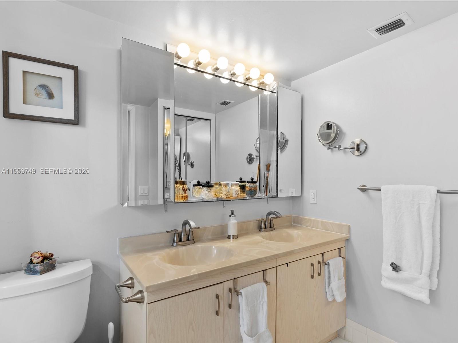 2004 Granada Drive, Unit O2 Coconut Creek, FL 33066 - Photo 10 of 26 a bathroom with a granite countertop sink a toilet and a mirror