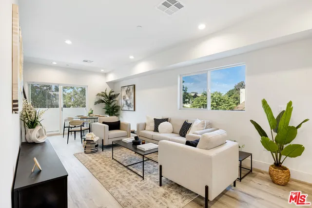 a living room with furniture potted plant and a large window