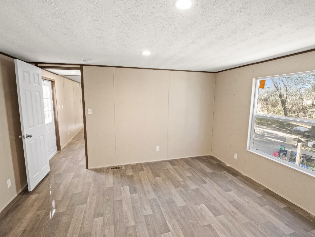 7214 Comstock Cove Lago Vista, TX 78645 - Photo 16 of 20 an empty room with wooden floor and windows