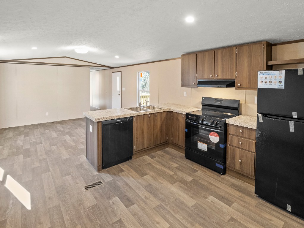 7214 Comstock Cove Lago Vista, TX 78645 - Photo 6 of 20 a kitchen with stainless steel appliances granite countertop a stove top oven a sink dishwasher and a refrigerator