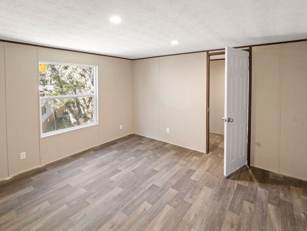 7214 Comstock Cove Lago Vista, TX 78645 - Photo 8 of 20 an empty room with wooden floor and a window
