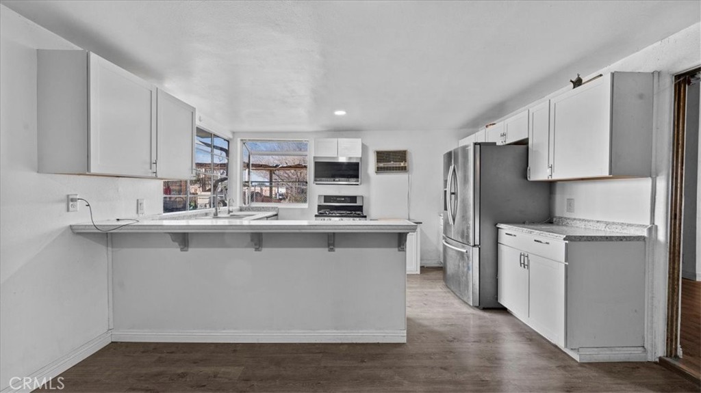 9728 East Avenue R Littlerock, CA 93543 - Photo 11 of 37 a kitchen with stainless steel appliances a sink stove refrigerator and cabinets