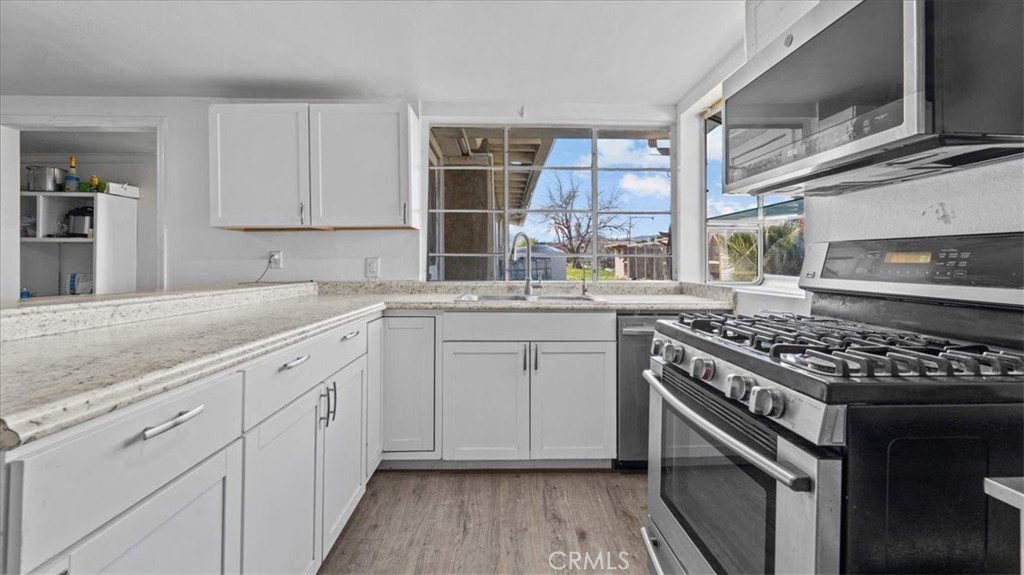 9728 East Avenue R Littlerock, CA 93543 - Photo 12 of 37 a kitchen with stainless steel appliances granite countertop a stove and a sink