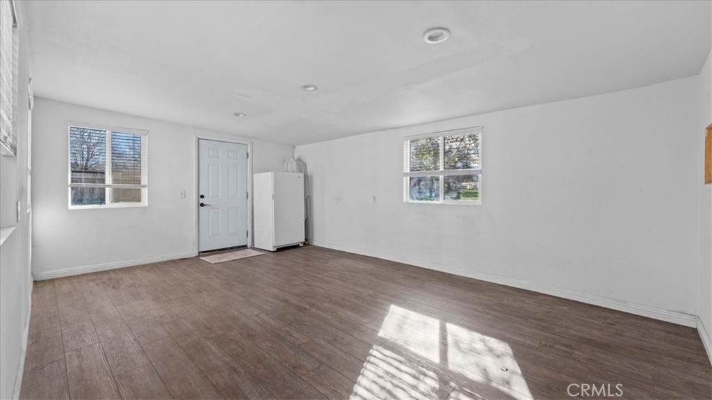 9728 East Avenue R Littlerock, CA 93543 - Photo 21 of 37 an empty room with wooden floor and windows