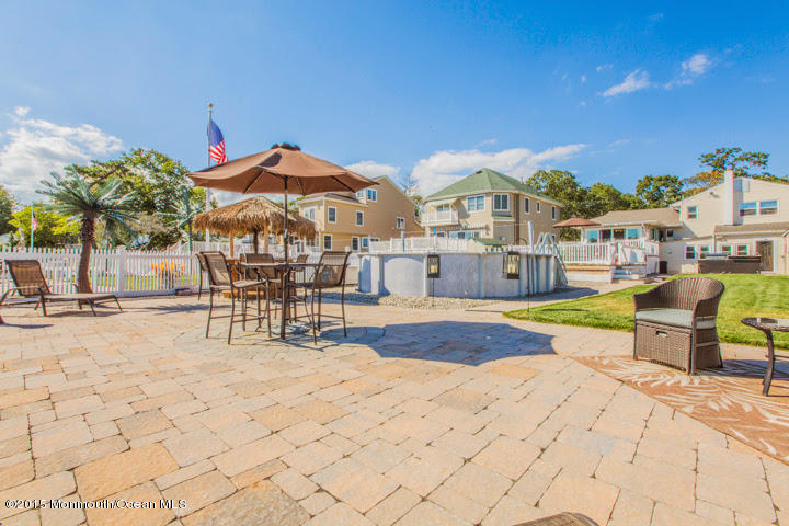 623 Bancroft Road Brick, NJ 08724 - Photo 28 of 91 a view of a swimming pool with lawn chairs under an umbrella