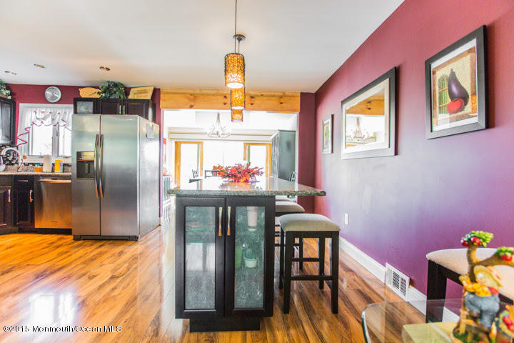 623 Bancroft Road Brick, NJ 08724 - Photo 48 of 91 a kitchen with stainless steel appliances kitchen island granite countertop a refrigerator a stove a dining table and chairs with wooden floor