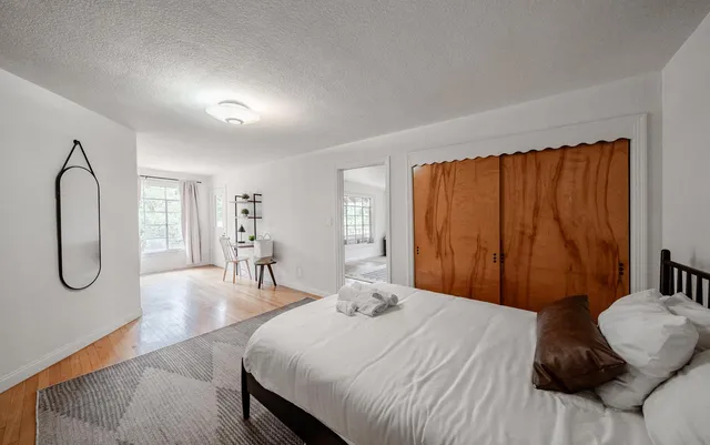 a bedroom with a large bed and chandelier