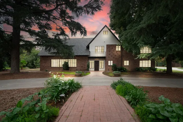 a front view of a house with a yard and trees