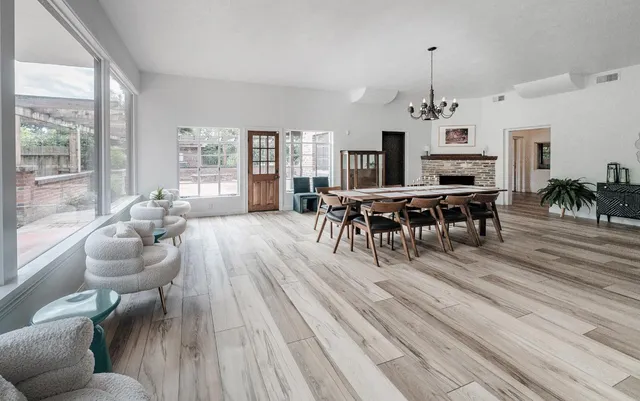 a living room with furniture a dining table and a large window