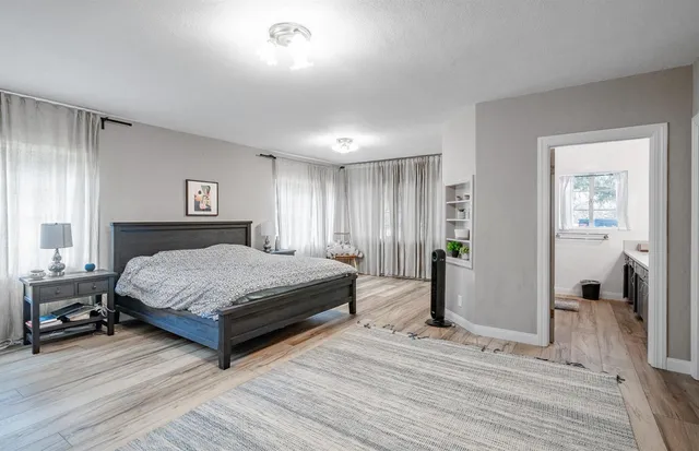 a bedroom with a bed and wooden floor