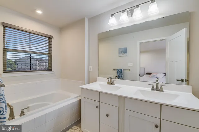 a bathroom with a tub a sink and mirror