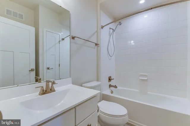a bathroom with a sink toilet vanity and shower