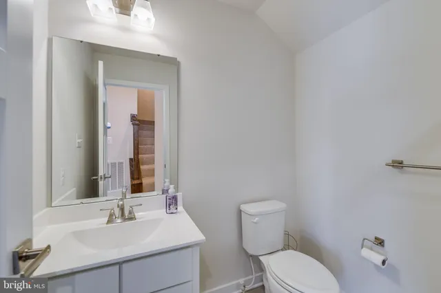 a bathroom with a toilet a sink and mirror
