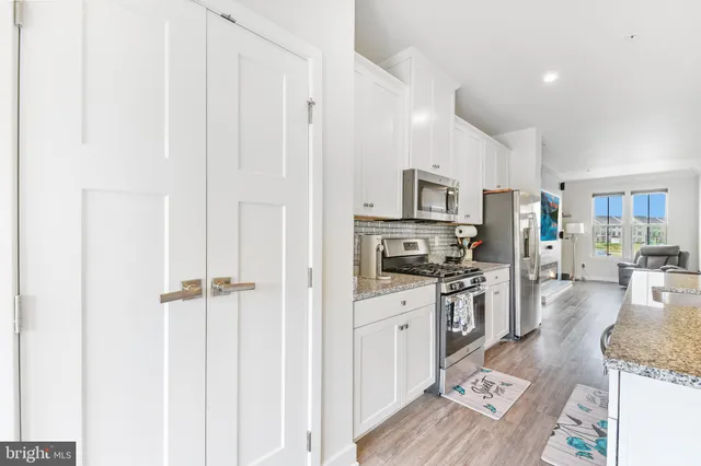 a kitchen with granite countertop a stove top oven a sink dishwasher and a refrigerator